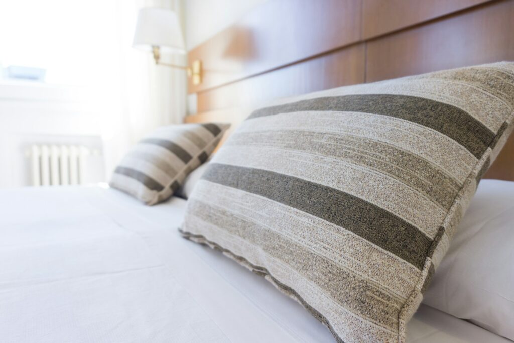 A close up view of pillows on a nicely made bed, representing peaceful feeling of being free from bed bugs.