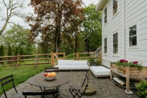 A beautiful backyard with gravel patio and outdoor furniture, representing the benefits of Bee & other stinging insect control.