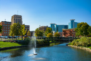 Downtown Kalamazoo, Michigan skyline with Arcadia Creek and a water fountain in the foreground.