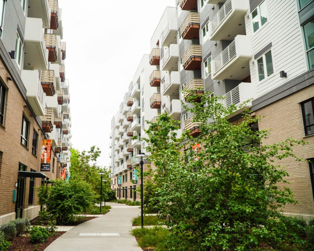 A courtyard pathway between two multistory condominium buildings, representing the type of location property mangers work to keep free of pests.